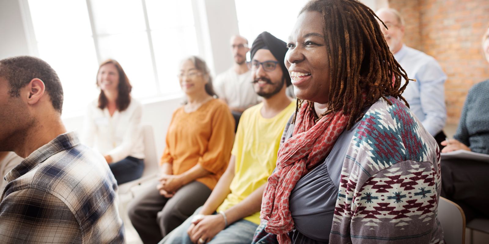 social justice business marketing, diverse group of business people in a bright lit room, interested and engaged and smiling